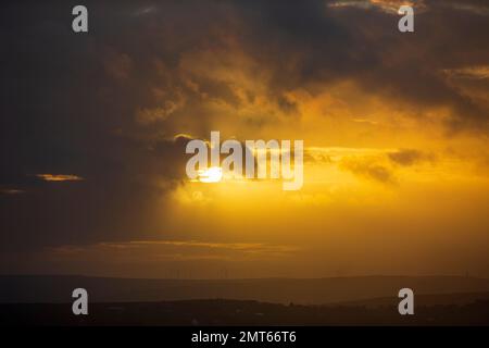 West Yorkshire, Großbritannien. 31. Januar 2023. Wetter in Großbritannien. Ein dramatischer Sonnenuntergang über dem Calder Valley mit einem Silhouetten Stoodley Pike Memorial in der Skyline. Das Calder Valley und die Städte Hebden Bridge und Halifax sind im BBC-Drama Happy Valley mit Sarah Lancashire zu sehen. Kredit: Windmill Images/Alamy Live News Stockfoto