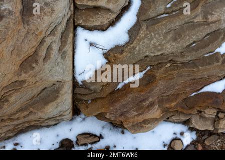 Struktur von Steingestein mit Schnee. Stockfoto