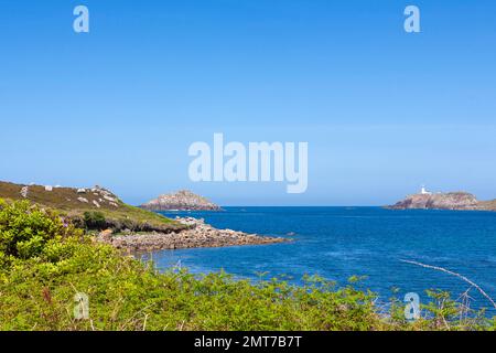 Blick von oben auf Gimble Porth auf Tresco, Isles of Scilly, Großbritannien, mit den Inseln Men-a-Vaur und Round Island mit seinem Leuchtturm in der Ferne Stockfoto