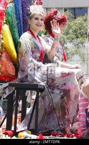 Die Grand Marshals Sharon und Kelly Osbourne fahren auf dem Santa Monica Boulevard auf einem farbenfrohen, mit Pailletten verzierten Floß mit Regenbogen und passenden Diademen und Kleidern während der alljährlichen Los Angeles Gay Pride Parade 40. Berichten zufolge wurden die Reality-TV-Stars von anti-schwulen Demonstranten konfrontiert, aber das Mutter-Tochter-Duo blieb unberührt und setzte sich fort. Kelly zeigte auch ihr Dekolleté und genoss einen Lutscher, später signierte sie Autogramme und Sharon umarmte einen Fan. Schätzungsweise 400 000 Personen nahmen an der Hochenergieveranstaltung Teil. Los Angeles, Kalifornien. 06/13/10. Stockfoto