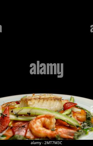 Gebratenes Fischsteak mit Garnelen und Gemüse Stockfoto