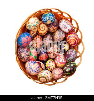Ostereier in einem Korb, isoliert auf weißem Hintergrund. Festlich dekorierter Pysanka-Pfad zum Schneiden von Eiern. Ukrainisches Symbol. Frühlingsferien. Stockfoto