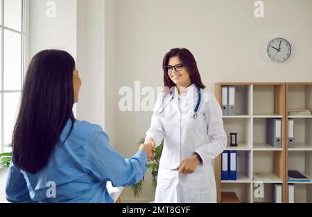 Lächelnde Ärztin begrüßt Patientin in der Arztpraxis Stockfoto