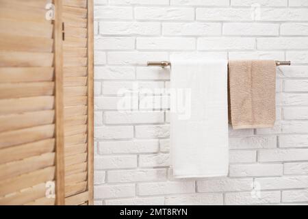 Frische, saubere Handtücher auf dem Kleiderbügel im Bad Stockfoto