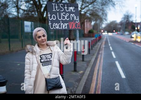 Manchester, Großbritannien. 01. Februar 2023. Ein Lehrer mit Plakat steht an der Streikpostenlinie. Tausende von Mitgliedern der Nationalen Bildungsunion (NEU) treten aufgrund der jahrelangen Lohnkürzungen der Regierung und der nicht an die Inflation angepassten Gehälter an die Streikposten. Kredit: Andy Barton/Alamy Live News Stockfoto