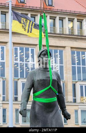 01. Februar 2023, Sachsen, Dresden: Die Bronzefigur „Trümmerfrau“ wird nach der Restaurierung mit dem Kran an ihren Standort vor dem Rathaus gehoben. Das Denkmal wurde seit Mitte November 2022 gereinigt und mit Schutzwachs bedeckt. Die „Trümmerfrau“ wurde ursprünglich 1952 als Eisenguss vom Dresdner Bildhauer Walter Reinhold geschaffen. Bisher wurden diese Zahlen überall als repräsentativ für die vielen Frauen angesehen, die nach 1945 Ziegelsteine aus den Schutt-Bergen gezogen haben, um nach dem zerstörerischen Zweiten Weltkrieg den Wiederaufbau zu ermöglichen. Foto: Robert Michael/dp Stockfoto