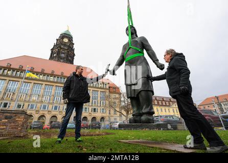 01. Februar 2023, Sachsen, Dresden: Die Bronzefigur „Trümmerfrau“ wird nach der Restaurierung mit dem Kran an ihren Standort vor dem Rathaus gehoben. Das Denkmal wurde seit Mitte November 2022 gereinigt und mit Schutzwachs bedeckt. Die „Trümmerfrau“ wurde ursprünglich 1952 als Eisenguss vom Dresdner Bildhauer Walter Reinhold geschaffen. Bisher wurden diese Zahlen überall als repräsentativ für die vielen Frauen angesehen, die nach 1945 Ziegelsteine aus den Schutt-Bergen gezogen haben, um nach dem zerstörerischen Zweiten Weltkrieg den Wiederaufbau zu ermöglichen. Foto: Robert Michael/dp Stockfoto