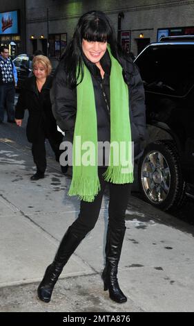 Die NCIS-Star Pauley Perrette trägt ein ganz schwarzes Outfit mit einem lindgrünen Schal, während sie vor den Studios „Late Show with David Letterman“ für Fotos posiert. New York, NY. 1/31/11. Stockfoto