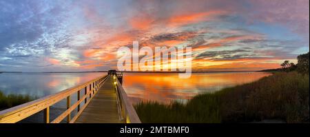 Panoramablick vom Kure Beach auf den goldenen Sonnenuntergang am Horizont in North Carolina Stockfoto