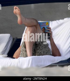 EXKLUSIV!! "America's Got Talent" Richter Piers Morgan und seine Autorin-Freundin Celia Walden entspannen sich zusammen in Miami Beach. Morgan genoss einige Ruhezeiten und schien in die Autobiografie von Michael VaughanÕs vertieft zu sein, Zeit, um sich zu erklären, während seine atemberaubende Freundin sich in einem roten Bikini sonnte. Miami, FL 1/14/2010 Stockfoto