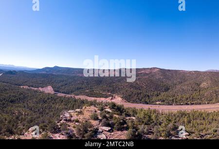 Ein Luftblick auf die State Route 260, die an einem sonnigen Tag durch grüne Wälder führt Stockfoto