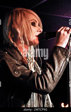 Taylor Momsen trägt eine schwarze Lederjacke und ein zerrissenes T-Shirt, das zu einem Kleid mit roten gemusterten Netzen und Stiefeln aus Lackleder mit superhohen Absätzen gepaart wurde. In der Wonder Bar in Asbury Park, NJ 3/18/11, tritt sie live mit ihrer Band The Pretty Reckless auf. Stockfoto