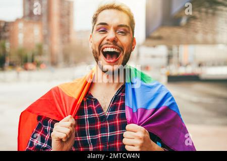 Schwuler Mann mit Make-up zum Spaß tragen lgbt-Regenbogenfahne im Freien - Hauptfokus auf Mund Stockfoto