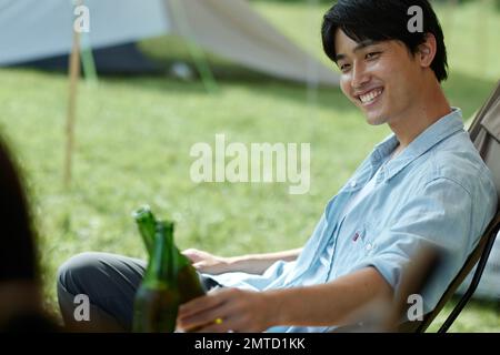 Junger Japaner auf dem Campingplatz Stockfoto