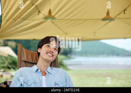 Junger Japaner auf dem Campingplatz Stockfoto