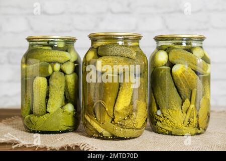 Hausgemachte Konserven. Eingelegte Snacks für den Winter. Eingelegte Gurken mit Kräutern und Gewürzen in Glasgefäßen. Stockfoto