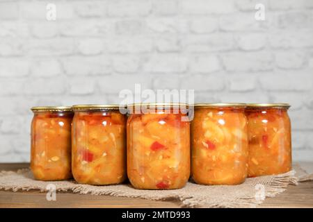 Zucchini in Dosen mit Gemüse in Glasgefäßen, auf einem Holztisch. Vorbereitungen für den Winter. Zucchini-Vorspeise. Stockfoto