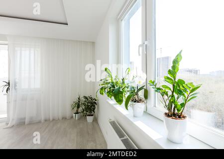 Abstrakter weißer wellenförmiger Vorhang im weißen Schlafzimmer-Apartment Stockfoto