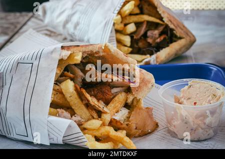 Ein traditionelles Gericht aus Zypern. Schweinefleisch Kebab ist vom Grill auf Holzkohlen und dann im Fladenbrot mit Salat serviert. Stockfoto