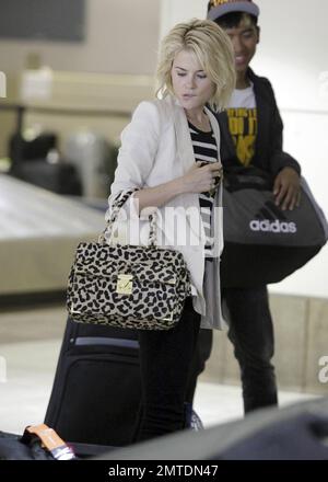 Die Schauspielerin Rachael Taylor sieht etwas verwirrt aus, als sie nach der Ankunft am Flughafen LAX ihr Gepäck an der Gepäckausgabe abholte. Los Angeles, Kalifornien. 5. August 2011. Stockfoto