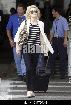 Die Schauspielerin Rachael Taylor sieht etwas verwirrt aus, als sie nach der Ankunft am Flughafen LAX ihr Gepäck an der Gepäckausgabe abholte. Los Angeles, Kalifornien. 5. August 2011. Stockfoto