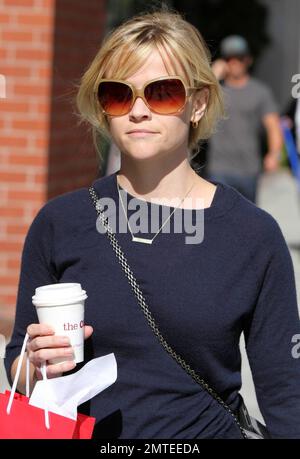 An einem schönen sonnigen Nachmittag ging die Schauspielerin Reese Witherspoon in einem schönen mehrstufigen Rock mit Blumenmuster, Pullover und einer einzigartigen Halskette mit rechteckigen Details hinaus, um einen Kaffee und einige Schweizer Schokolade vom Chocolatier Teuscher zu holen. Witherspoons neuester Film "Wasser für Elefanten" mit Robert Pattinson wird nächsten Monat Premiere haben. Los Angeles, Kalifornien. 03/08/11. Stockfoto