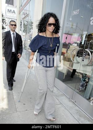 Die auf Barbados geborene Schönheit, Rihanna, wurde heute gesehen, wie sie sich durch die Geschäfte schlängelte, obwohl sie auf Krücken stand und eine Stütze am Fuß trug. Die Sängerin heiterte sich mit einem Einkaufsbummel auf der Melrose Avenue und im Grove auf und verwöhnte sich und ihre Freundin mit Eis. Los Angeles, Kalifornien, 8/1/07. Alle Stockfoto