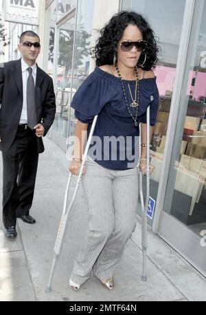 Die auf Barbados geborene Schönheit, Rihanna, wurde heute gesehen, wie sie sich durch die Geschäfte schlängelte, obwohl sie auf Krücken stand und eine Stütze am Fuß trug. Die Sängerin heiterte sich mit einem Einkaufsbummel auf der Melrose Avenue und im Grove auf und verwöhnte sich und ihre Freundin mit Eis. Los Angeles, Kalifornien, 8/1/07. Alle Stockfoto