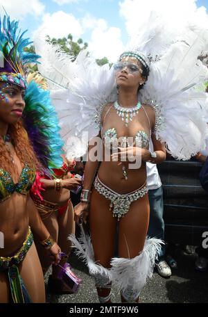 Rihanna trägt fast alles in einem extrem knappen, mit Schmuck besetzten Bikini, während sie die Kadomoment Day Parade auf Barbados besucht. Das kaum angelegte Kostüm enthielt auch ein federndes Kopfkleid und Riri trug ihre eigene Silberflasche für die Party mit sich. Der Kadooment Day ist der Höhepunkt des Crop Over Harvest Festivals und wird mit einer riesigen Parade und einem Sommerkarneval auf der Straße gefeiert. Georgetown, Barbados. 5. August 2013. Stockfoto