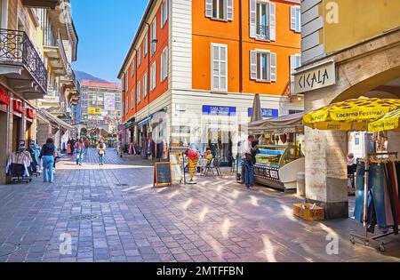 LOCARNO, SCHWEIZ - 28. MÄRZ 2022: Die Touristenstraße Via alla Ramogna, gesäumt mit historischen Häusern, Geschäften, Restaurants und Imbissständen, am März Stockfoto