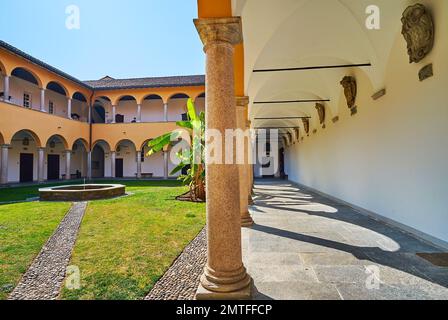 Die mittelalterliche schattige Arkade mit Rippengewölbedecke und Steinsäulen im Innenhof des Collegio Papio, Ascona, Schweiz Stockfoto