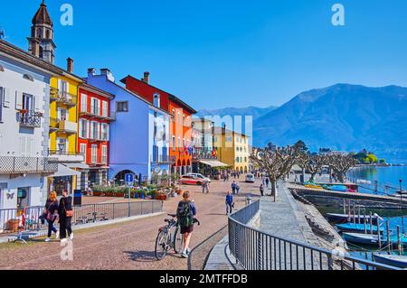 ASCONA, SCHWEIZ - 28. MÄRZ 2022: Piazza Giuseppe Motta am See am Ufer des Lago Maggiore mit bunten Häusern und Booten im Hafen, am 28. März in A Stockfoto