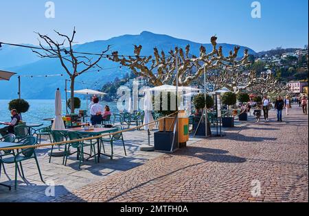 ASCONA, SCHWEIZ - 28. MÄRZ 2022: Piazza Giuseppe Motta mit gemütlichen Restaurants und Cafés im Freien am Ufer des Lago Maggiore, am 28. März in AS Stockfoto