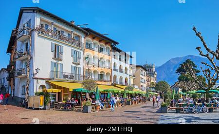 ASCONA, SCHWEIZ - 28. MÄRZ 2022: Piazza Giuseppe Motta mit Stadthäusern und Terrassen von Touristenrestaurants, am 28. März in Ascona Stockfoto