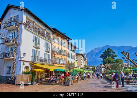 ASCONA, SCHWEIZ - 28. MÄRZ 2022: Das dichte Wohnhaus auf der Piazza Giuseppe Motta mit wunderschönen Terrassen, dekoriert mit grünen Pflanzen und Blumen in P. Stockfoto