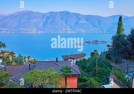 Genießen Sie die alpine Landschaft, den verschwommenen Lago Maggiore und die winzigen Brissago-Inseln, die Sie vom Garten in Ronco Sopra Ascona, Schweiz, aus sehen können Stockfoto