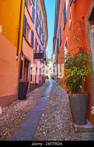 Gehen Sie die enge Hügellandschaft Via Panigari hinauf, gesäumt mit alten Wohnhäusern, kleinen Geschäften und Cafés, Locarno, Schweiz Stockfoto