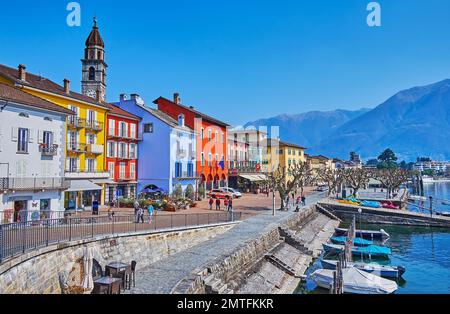 ASCONA, SCHWEIZ - 28. MÄRZ 2022: Piazza Giuseppe Motta blickt auf den Lago Maggiore mit festgefahrenen Fischerbooten, am 28. März in Ascona Stockfoto