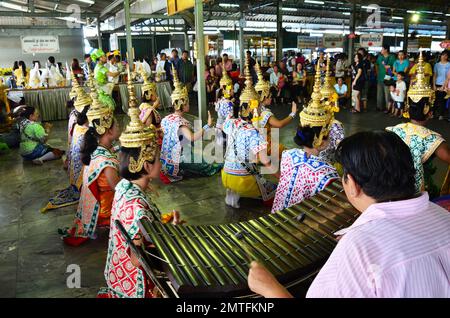 Thailändische Tänzerinnen beten Respekt und machen ein Votivopfer, lösen ein Gelübde auf die Luang Por Sothon buddha Statue im Wat Sothon Wararam Worawihan Stockfoto