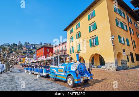 ASCONA, SCHWEIZ - 28. MÄRZ 2022: Der hellblaue Oldtimer-Touristenzug auf der historischen Piazza Giuseppe Motta, am 28. März in Ascona Stockfoto