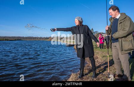 Kelso, River Tweed, Scottish Borders, Schottland, Großbritannien. Offizielle Eröffnung der Lachs-Fangsaison River Tweed 2023. In Kelso an der schottischen Grenze. Mairi Gougeon MSP, Kabinettssekretärin der schottischen Regierung für Angelegenheiten des ländlichen Raums und Inseln, segnet den Fluss Tweed mit einem Schluck Whisky, während sie offiziell die Lachs-Fangsaison 2023 des Flusses eröffnet. Der Tweed ist der produktivste Lachsfluss im Vereinigten Königreich, zieht Angler aus aller Welt an und trägt jährlich rund £24 Millionen Euro zur lokalen Wirtschaft bei. Rechts abgebildet ist die Tweed River Commission - Vorsitzender Pete Stockfoto