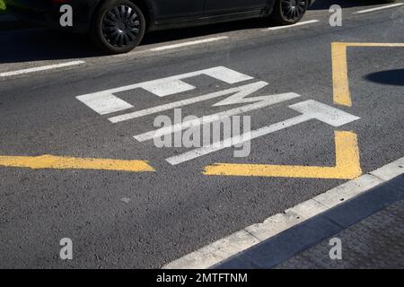 Nahaufnahme eines indikativen, auf den Asphalt der EMT (Municipal Transport Company)-Bushaltestelle in der Spur, wo sie in einem großen Spanischen umherfliegt Stockfoto