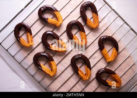 Churros mit dunkler Schokolade in einer spanischen Konditorei. Stockfoto