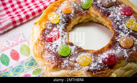 Roscón de reyes. Das roscón de Reyes ist ein Brötchen aus einem süßen Teig in Form eines Ringkörpers, der mit kandierten, kandierten oder kristallklaren Scheiben verziert ist Stockfoto