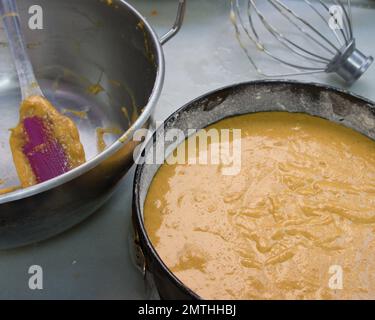 Zum Abschluss der Zubereitung eines Karottenkuchen befindet sich im Vordergrund eine Schüssel mit dem rohen Teig, der zum Backen bereit ist Stockfoto