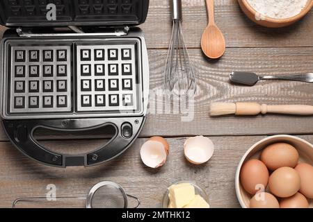 Flach liegend mit Zutaten und belgischem Waffeleisen auf Holztisch Stockfoto