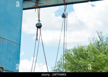Alte Eisenkonstruktion mit Hakenketten auf der Straße Stockfoto