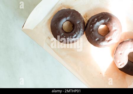 Schokoladen-Donuts in einer offenen Schachtel, Draufsicht Stockfoto