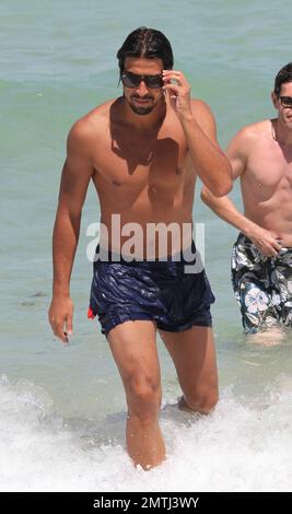 Deutscher Real Madrid Mittelfeldspieler Sami Khedira und Freundin Lena Gercke genießen einen weiteren Tag am Strand. Die beiden schwammen zusammen, nahmen sich etwas Zeit für einen romantischen Kuss und entspannten sich später auf ihren Liegestühlen. Miami Beach, Florida 13. Juli 2012. Stockfoto