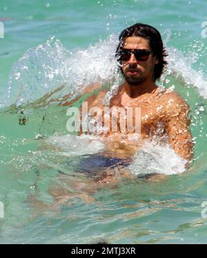 Deutscher Real Madrid Mittelfeldspieler Sami Khedira und Freundin Lena Gercke genießen einen weiteren Tag am Strand. Die beiden schwammen zusammen, nahmen sich etwas Zeit für einen romantischen Kuss und entspannten sich später auf ihren Liegestühlen. Miami Beach, Florida 13. Juli 2012. . Stockfoto